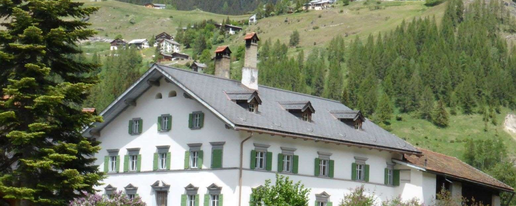 Haus Buol Bergün Sommer, im Hintergrund das schöne Bergdorf Latsch